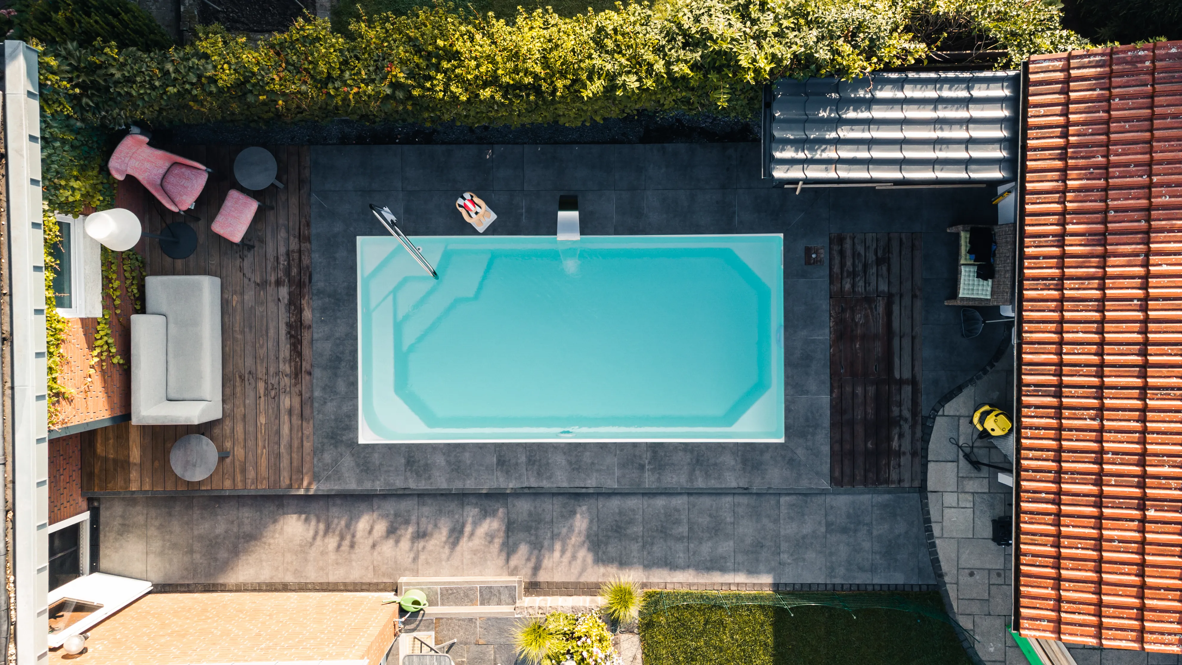 Poolgarten von oben: Lounge am Wasser. Sitzplatz, Wasser, Grün — nebeneinander statt hintereinander.