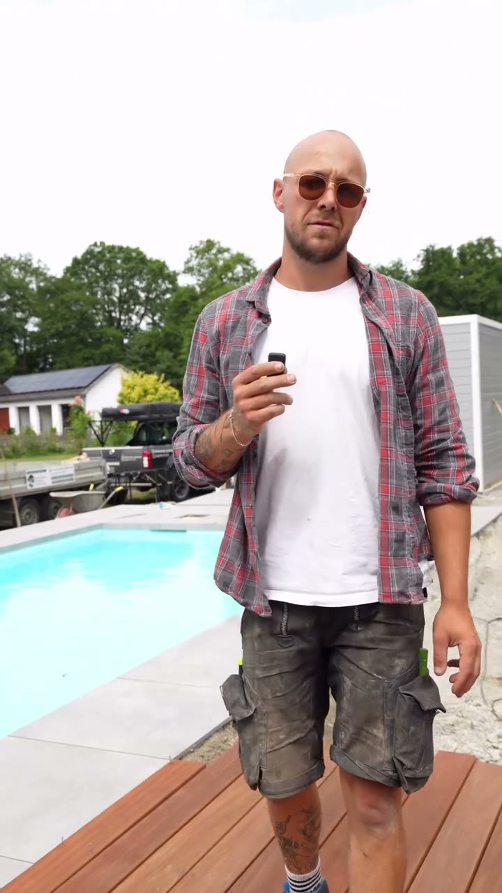 Jan Hartkämper steht am fertigen Pool mit Holzdeck und erklärt das Projekt.